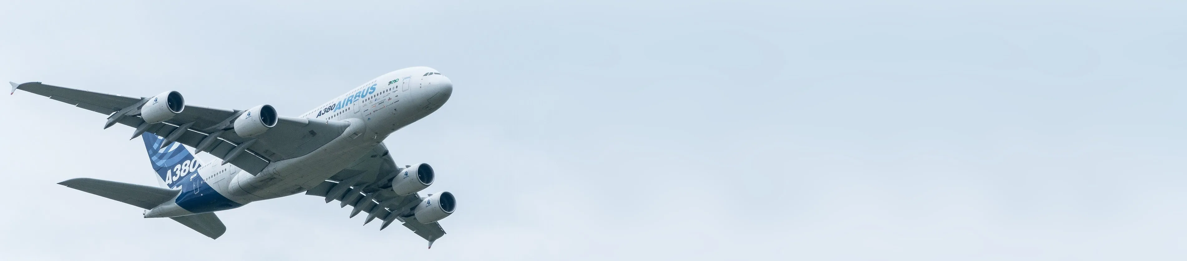 Airbus A380 in flight against a pale sky